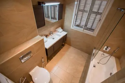 a bathroom with a sink and a toilet and a mirror at Imperial Apartment by Connexion in Cannes