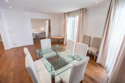a dining room with a glass table and white chairs at Imperial Apartment by Connexion in Cannes