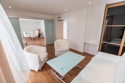 a living room with white chairs and a table at Imperial Apartment by Connexion in Cannes