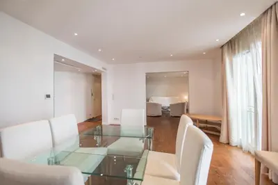 a dining room with a glass table and white chairs at Imperial Apartment by Connexion in Cannes