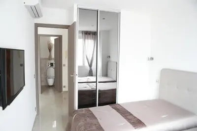 a white bedroom with a bed and a mirror at 3P lumineux rénové derrière la Croisette in Cannes