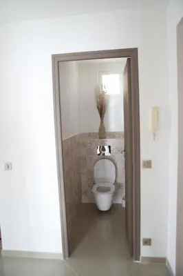 a bathroom with a toilet with a vase on the wall at 3P lumineux rénové derrière la Croisette in Cannes