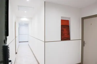 a hallway with white walls and a glass door at Appartements Foch in Cannes
