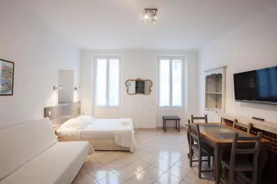 a living room with a couch and a bed and a table at Appartements Foch in Cannes