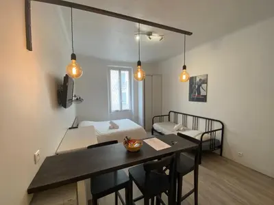 a room with a dining table and a bed at Appartements Foch in Cannes