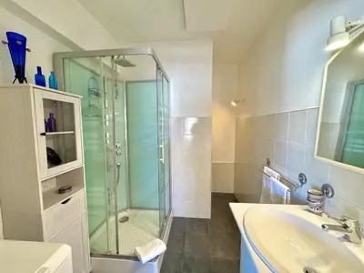 a bathroom with a glass shower and a sink at Ibis Studio 5380 in Cannes