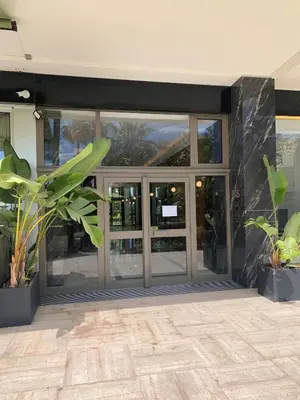 a large glass door in a building with plants at Ibis Studio 5380 in Cannes