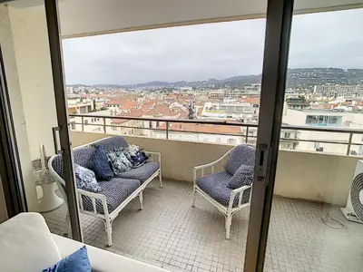 a balcony with two chairs and a view of a city at Ibis Studio 5380 in Cannes