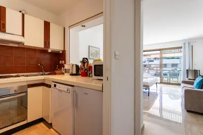 a kitchen with white appliances and a living room at Résidence Gray d'Albion Studio BRA507 in Cannes