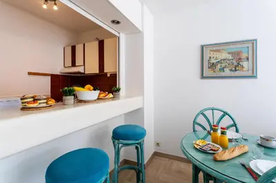 a dining room with a table and chairs and a kitchen at Résidence Gray d'Albion Studio BRA507 in Cannes