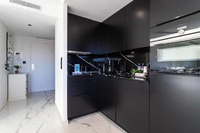 a black kitchen with black cabinets and appliances at Résidence Gray d'Albion appartement DEL562 in Cannes