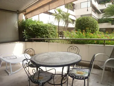 a patio with a table and chairs and an umbrella at Résidence Gray d'Albion Studio LOU511 in Cannes