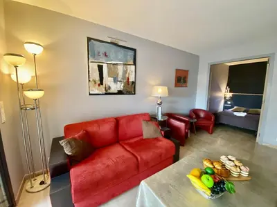 a living room with a red couch and a table at Résidence Gray d'Albion 2P 5402 in Cannes