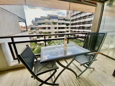 a glass table with two wine glasses on a balcony at Résidence Gray d'Albion 2P 5402 in Cannes
