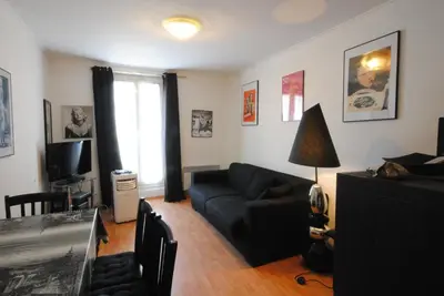 a living room with a black couch and a television at Les Serbes 2P RET29 in Cannes
