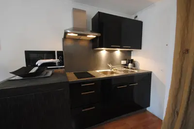 a kitchen with black cabinets and a sink at Les Serbes 2P RET29 in Cannes