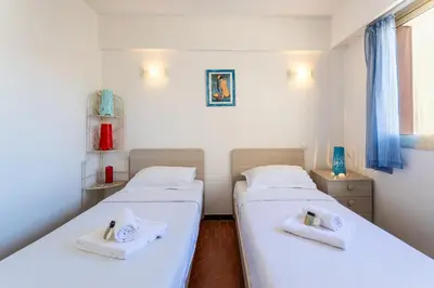 two beds in a room with white sheets and towels at Le Minerve 3P DEB5515 in Cannes