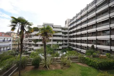 an apartment building with palm trees in front of it at Résidence Gray d'Albion 2P NAP558 in Cannes