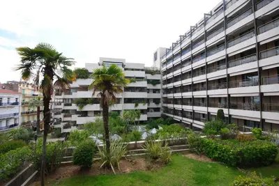 an apartment building with palm trees in front of it at Résidence Gray d'Albion 2P NAP558 in Cannes