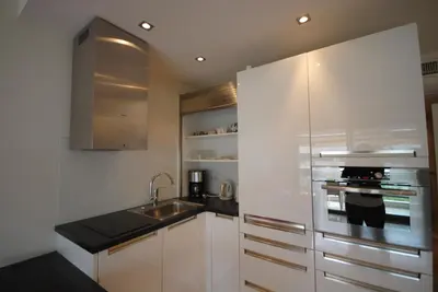 a kitchen with white cabinets and a stainless steel refrigerator at Résidence Gray d'Albion 2P NAP558 in Cannes