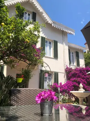 a house with purple flowers in front of it at Hotel Chalet De L'isere in Cannes