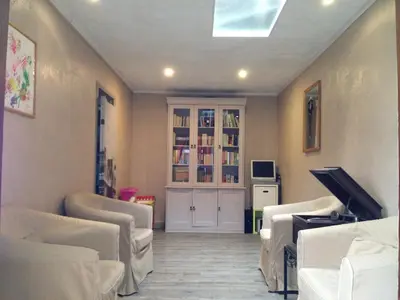 a waiting room with white chairs and a tv at Hotel Chalet De L'isere in Cannes