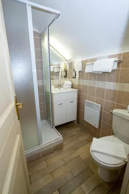 a bathroom with a shower and a toilet and a sink at Hotel Chalet De L'isere in Cannes