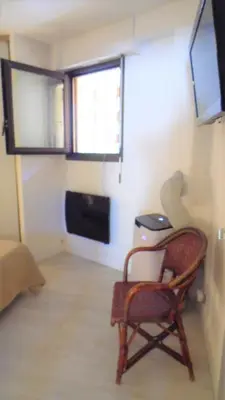 a living room with a chair and a window at CANNES plage 2mn/45m2/vue mer/inernet/clim/parking privé in Cannes