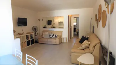 a living room with a couch and a bed at CANNES plage 2mn/45m2/vue mer/inernet/clim/parking privé in Cannes