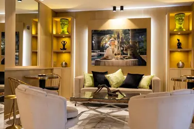 a living room with a couch and a table and chairs at Hotel Le Fouquet's in Cannes