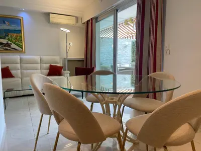 a dining room with a glass table and chairs at Hotel Le Fouquet's in Cannes