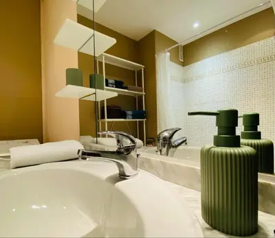 a bathroom with a sink and a green soap dispenser at Studio Cannes la Croisette in Cannes