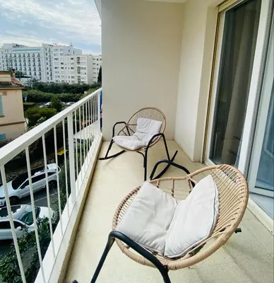 two chairs on a balcony with a view of a city at Studio Cannes la Croisette in Cannes