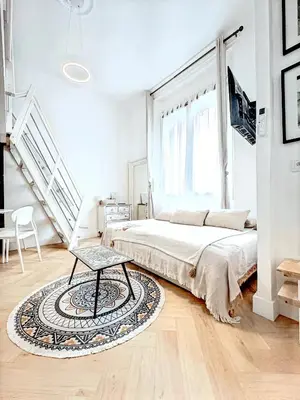 a white bedroom with a bed and a rug at Mini Duplex 50m du Vieux Port in Cannes