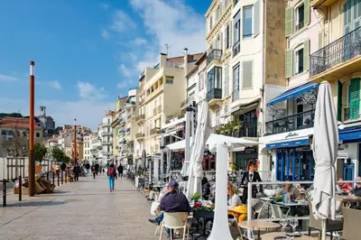 a street in a city with people sitting at tables at Mini Duplex 50m du Vieux Port in Cannes