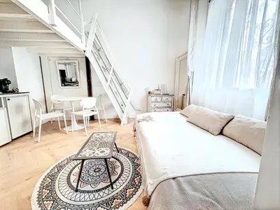 a white room with a bed and a table at Mini Duplex 50m du Vieux Port in Cannes
