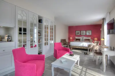 a swimming pool with chairs and a hat next to it at La Bastide de l'Oliveraie in Cannes