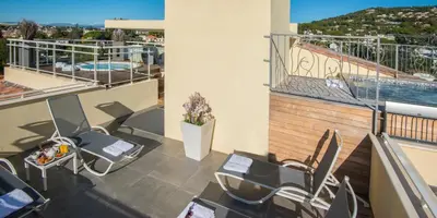 a swimming pool with a white chair and a table at La Bastide de l'Oliveraie in Cannes