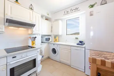 a kitchen with white cabinets and a washer and dryer at Apartment 2 bedrooms 2 bathrooms clear view in Palm beach area in Cannes