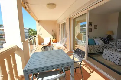 a balcony with a table and chairs in a living room at Apartment 2 bedrooms 2 bathrooms clear view in Palm beach area in Cannes