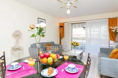 a living room with a table with a bowl of fruit at Palais Royal YourHostHelper in Cannes