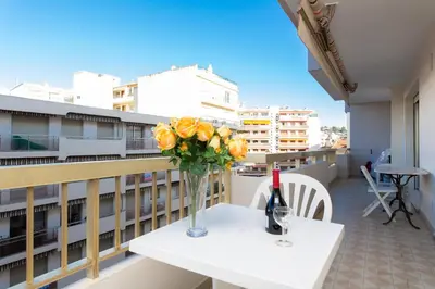 a vase of flowers on a table on a balcony at Palais Royal YourHostHelper in Cannes