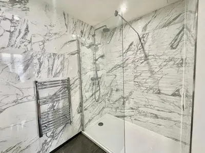 a bathroom with a shower and a marble wall at Jaurès Home by Welcome to Cannes in Cannes
