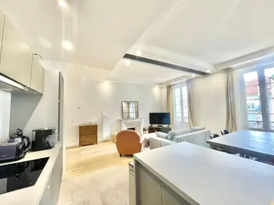 a kitchen and a living room with a table at Jaurès Home by Welcome to Cannes in Cannes