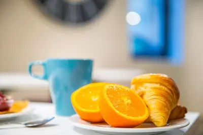 a plate with oranges and croissants on a table at ibis budget Cannes Centre Ville in Cannes
