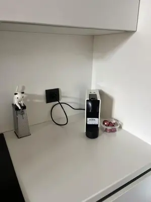 a white counter top with a phone and a charger at keep in touch 2 CHAMBRES AVEC TERRASSE ET GARAGE in Cannes