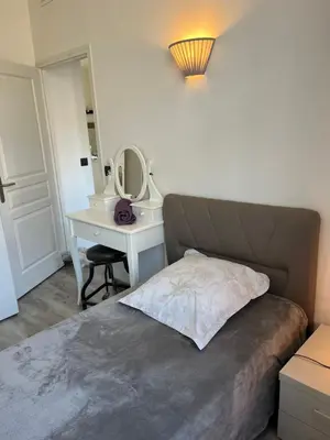 a bedroom with a bed and a desk with a mirror at keep in touch 2 CHAMBRES AVEC TERRASSE ET GARAGE in Cannes