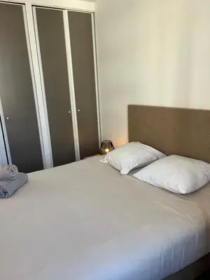 a bed with two pillows on it in a room at keep in touch 2 CHAMBRES AVEC TERRASSE ET GARAGE in Cannes