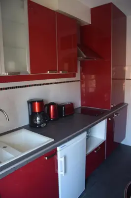 a red kitchen with red cabinets and a sink at 5 min to sea and Palais des Festivals in Cannes