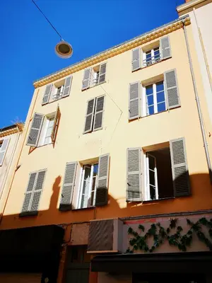 a building with shuttered windows and a blue sky at 5 min to sea and Palais des Festivals in Cannes